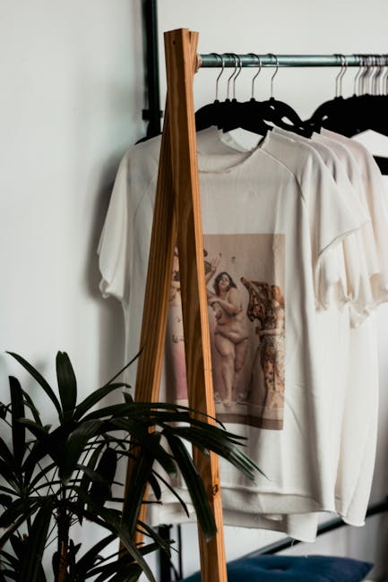 Stylish indoor clothing rack featuring white t-shirts with classical art prints in a minimalist setting.